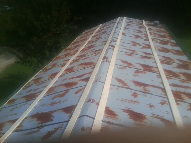 Rusted metal roof panels with new wood purlins before replacement — Storm Damage Roof Repair in Clawson by Roofing Brothers