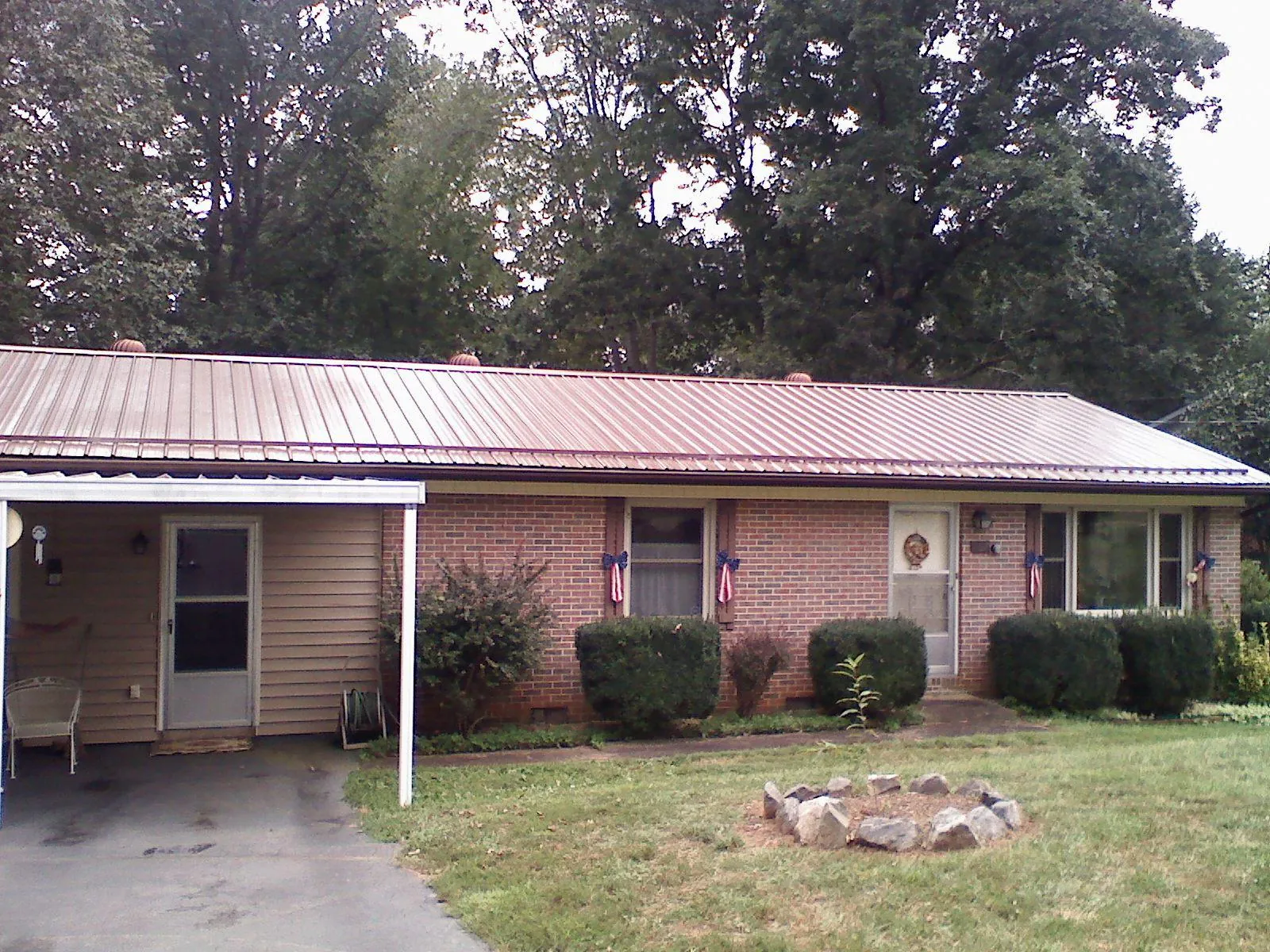 Bronze metal roof and carport on a brick ranch home — Roof Repair work by our crew in Clawson